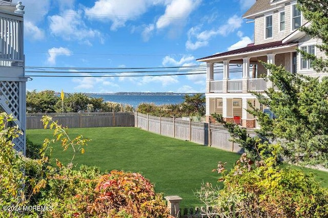 view of yard featuring a water view and a fenced backyard