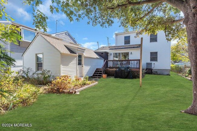 back of property featuring a yard and a wooden deck