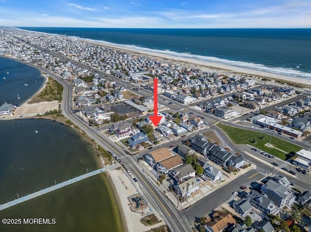 drone / aerial view with a beach view and a water view