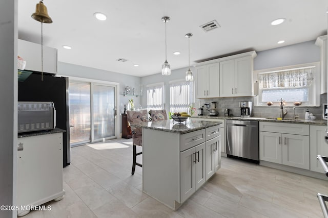 kitchen with stainless steel dishwasher, visible vents, a sink, and a healthy amount of sunlight