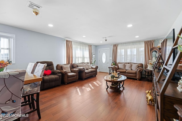 living room with plenty of natural light, wood finished floors, visible vents, and recessed lighting