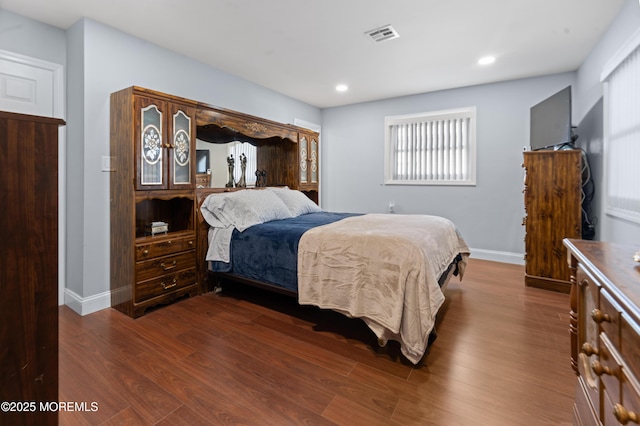bedroom featuring baseboards, dark wood-style flooring, multiple windows, and visible vents