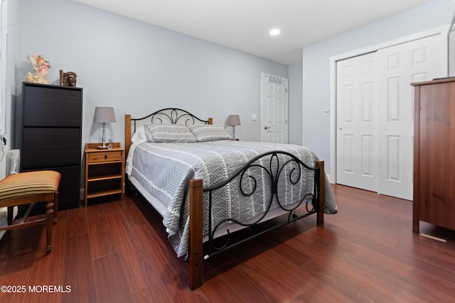 bedroom with recessed lighting, dark wood-type flooring, and a closet