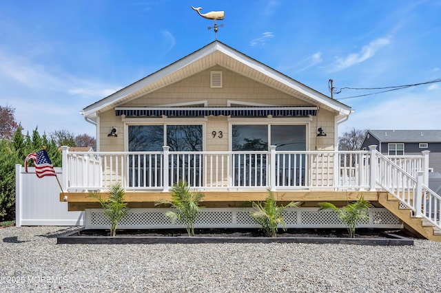 rear view of property featuring a deck and stairs