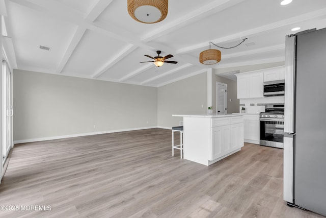kitchen featuring vaulted ceiling with beams, a breakfast bar, stainless steel appliances, visible vents, and open floor plan