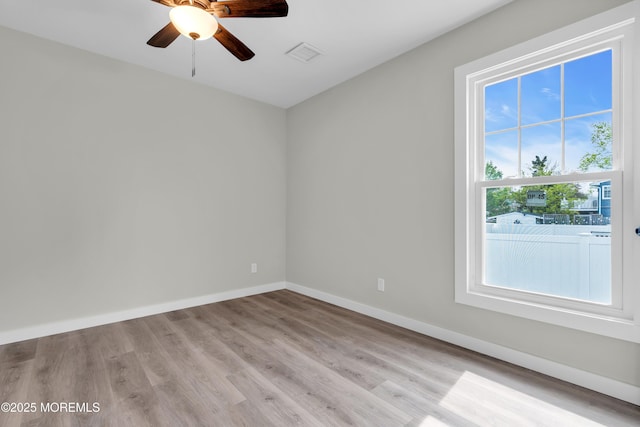 spare room with visible vents, ceiling fan, light wood-style flooring, and baseboards