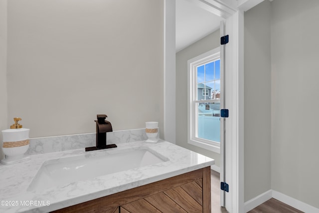 bathroom featuring baseboards, wood finished floors, and vanity