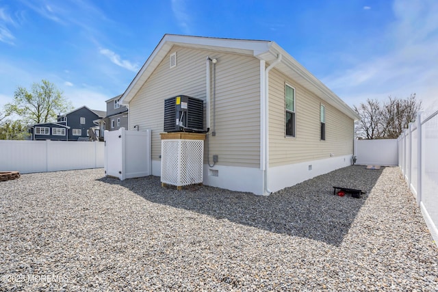 view of side of home with a fenced backyard and crawl space