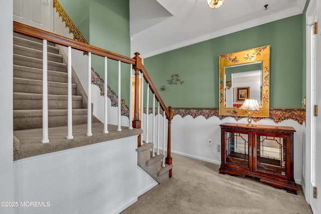 stairs with carpet floors and ornamental molding