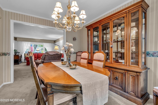 dining room featuring wallpapered walls, a chandelier, light carpet, and ornamental molding