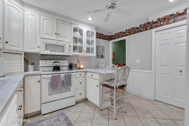 kitchen featuring white appliances, white cabinetry, glass insert cabinets, and light tile patterned floors