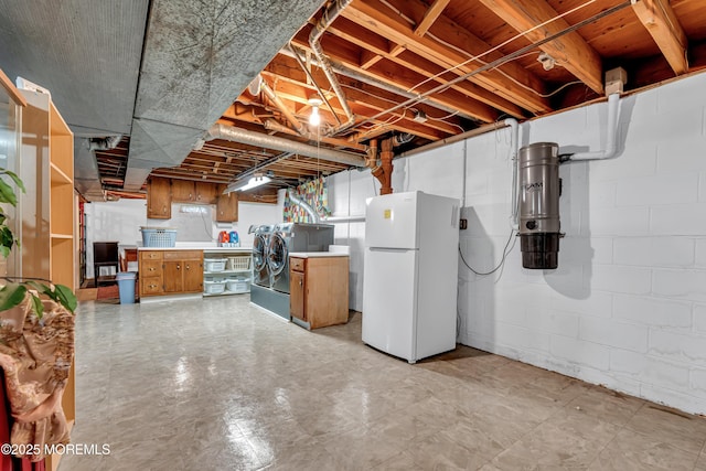 unfinished basement with freestanding refrigerator and washer / dryer