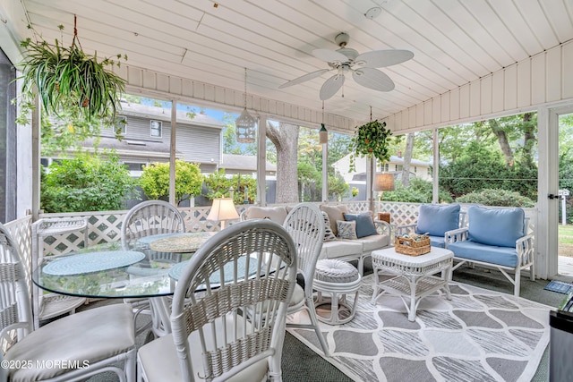 sunroom / solarium featuring outdoor dining area, an outdoor living space, ceiling fan, and a wealth of natural light