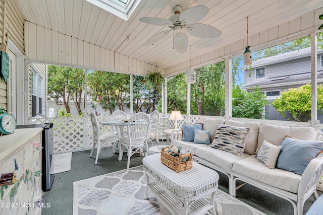 sunroom featuring an outdoor hangout area, outdoor dining space, ceiling fan, and a skylight