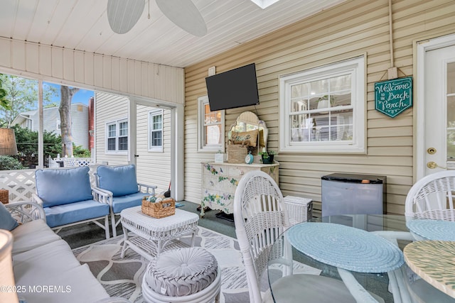 sunroom with a ceiling fan and an outdoor hangout area