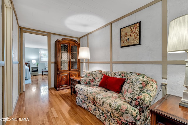 living area with a textured wall and light wood-style flooring
