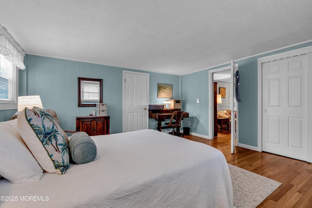 bedroom with baseboards and wood finished floors