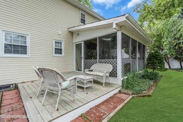 deck with a sunroom and a yard