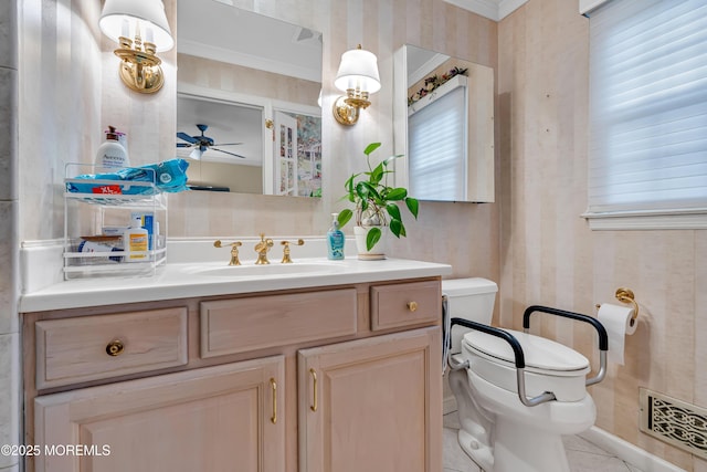 bathroom featuring vanity, toilet, a ceiling fan, visible vents, and ornamental molding