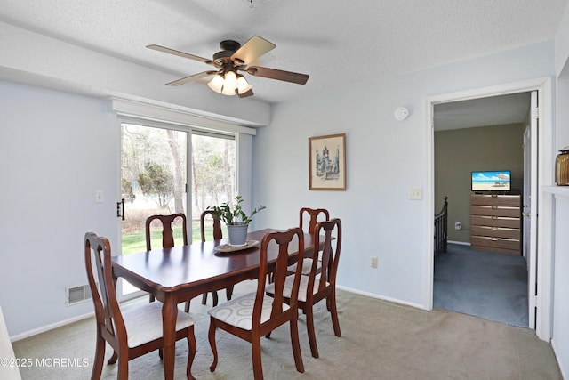 dining space with visible vents, ceiling fan, a textured ceiling, and carpet