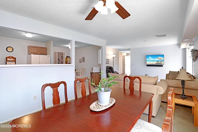 dining area with visible vents, a ceiling fan, and a textured ceiling