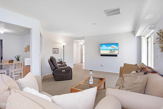 carpeted living area with visible vents and a textured ceiling