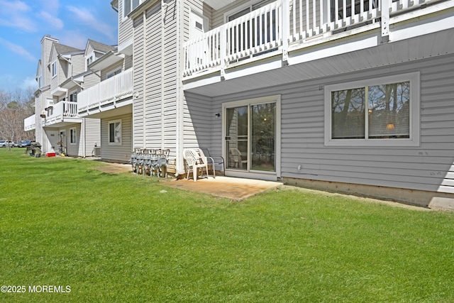 back of property featuring a yard, a patio area, and a balcony