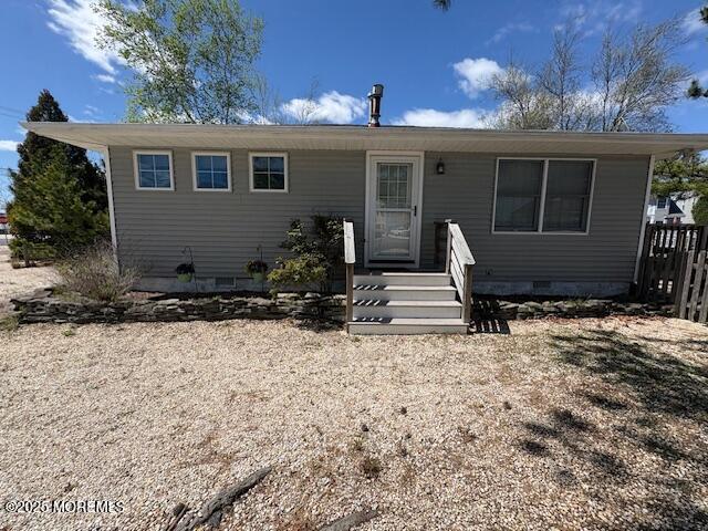 view of front of house with fence and crawl space