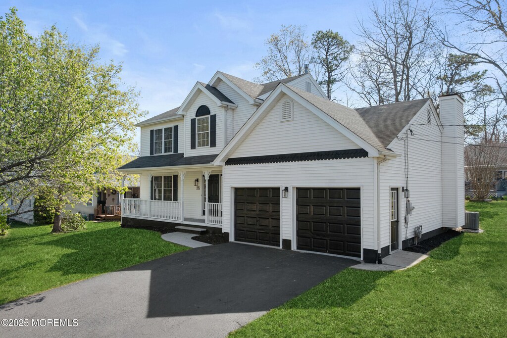 1534 Forecastle Ave, Manahawkin, NJ 08050 - traditional home featuring a porch, a front lawn, central air condition unit, a garage, and driveway
