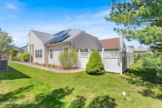 87 Halsted Dr, Manchester, NJ 08759 - view of side of home featuring a lawn, fence, solar panels, and roof with shingles