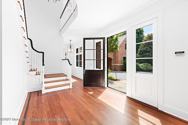 entryway featuring stairway, wood finished floors, and baseboards