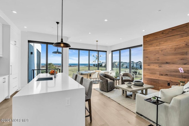 living area featuring recessed lighting, light wood-style flooring, and a water view