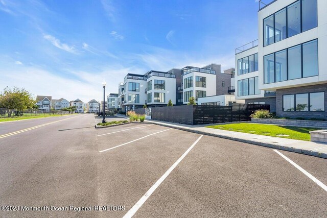 uncovered parking lot with a residential view and fence