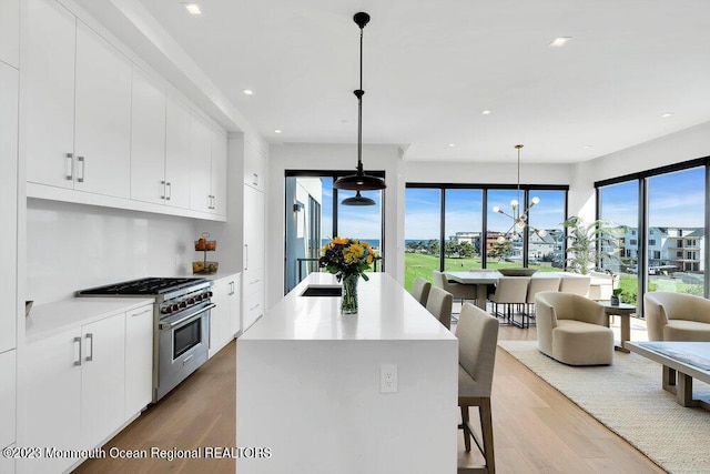 kitchen featuring high end range, light countertops, a breakfast bar, and light wood-style flooring
