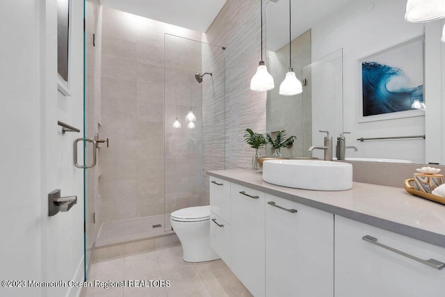 bathroom with a stall shower, toilet, tile patterned flooring, and vanity