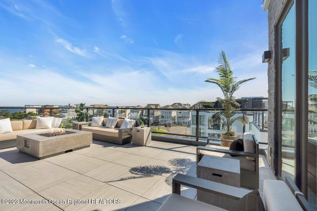 view of patio with a residential view and an outdoor living space with a fire pit
