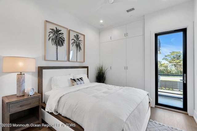 bedroom with light wood-style flooring, visible vents, access to exterior, a closet, and recessed lighting