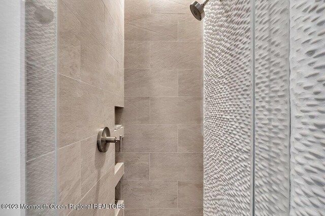 interior details featuring a tile shower