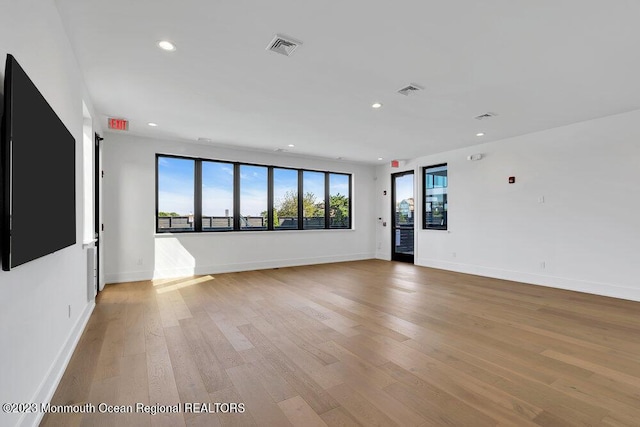unfurnished room featuring baseboards, light wood-type flooring, and recessed lighting