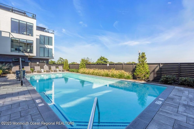 pool featuring a fenced backyard and a patio area