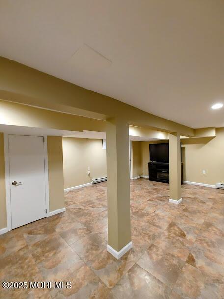 finished below grade area with recessed lighting, baseboards, and baseboard heating