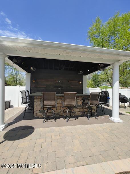 view of patio featuring fence and outdoor dry bar