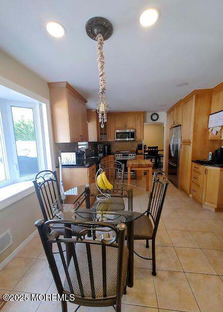 dining room with light tile patterned floors, baseboards, and visible vents