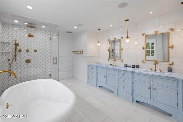 full bath with tile walls, a sink, a shower stall, a freestanding bath, and double vanity