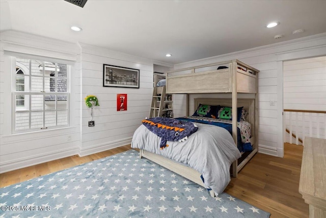 bedroom with wood finished floors, recessed lighting, and ornamental molding