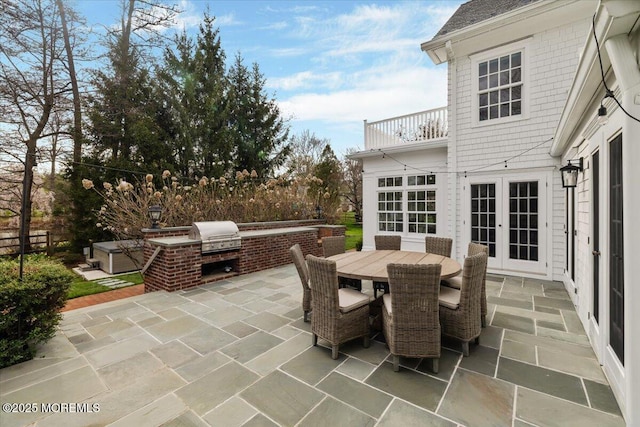 view of patio / terrace with area for grilling, outdoor dining space, french doors, and a balcony