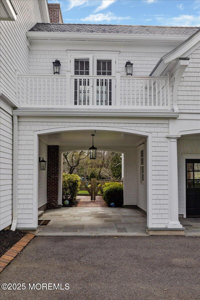 entrance to property featuring a balcony and brick siding