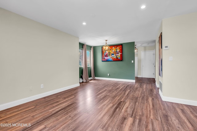 empty room featuring baseboards, recessed lighting, and wood finished floors