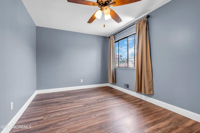 unfurnished room with visible vents, a ceiling fan, baseboards, and wood finished floors