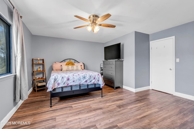 bedroom featuring baseboards, a ceiling fan, and wood finished floors